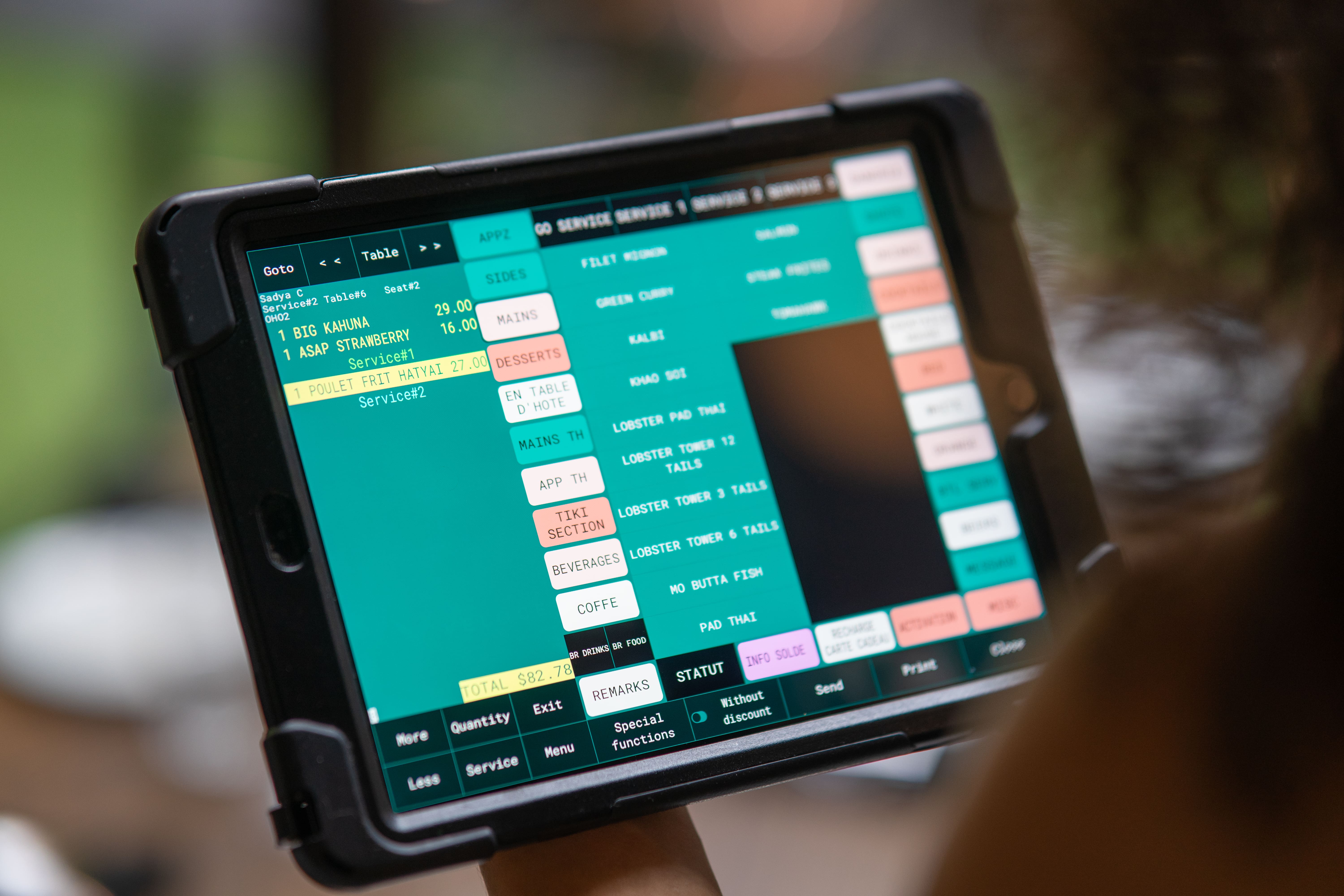A close-up of the Veloce POS interface on a POS, displaying a variety of drink orders in a bar setting.